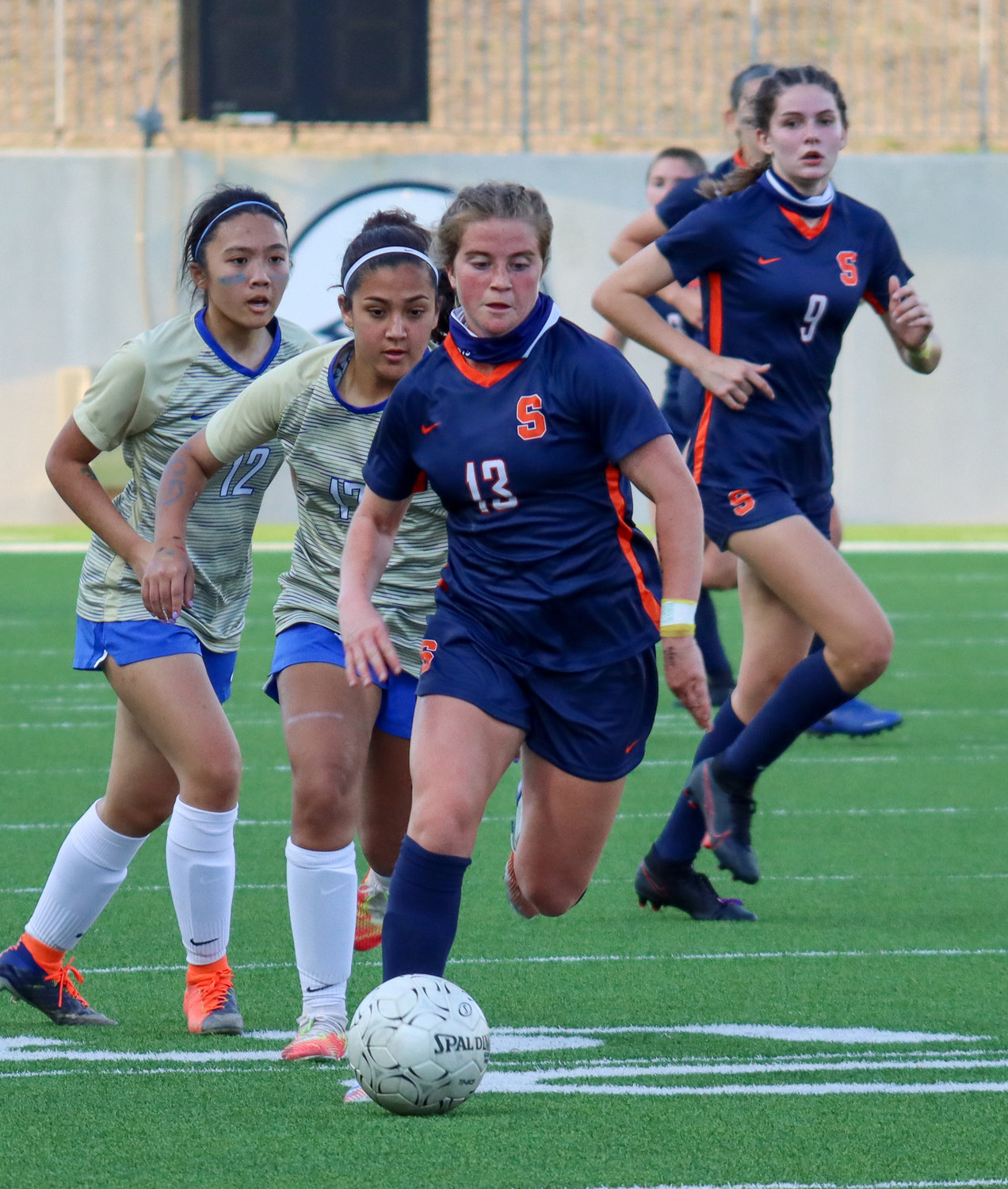 Seven Lakes senior midfielder Phoebe Harpole moves downfield ahead of Elkins defenders during the Spartans’ 7-0 Class 6A bi-district playoff win on Friday, March 26, at Legacy Stadium.